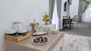 Een ontbijt met een koffiezetapparaat, champagne, fruit en aardbeien op een tafel.