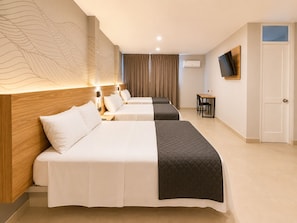 A hotel room with two beds, a desk, a TV, and a wall-mounted air conditioner. - Senoma Hotel - Adults only (Ica)