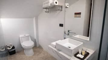 Un baño moderno con inodoro, lavabo, espejo y toallero.
