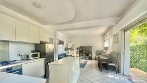 A modern kitchen with white cabinets, a built-in microwave, and a gas stove.