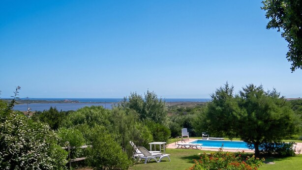 A pool with a view of the sea, surrounded by greenery and a clear sky. - Villa Sirenetta - Punta De Su Tu... (Punta de su turrione)