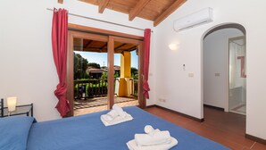 Hotelkamer met een bed, twee handdoeken, een nachtkastje, een airconditioning en uitzicht op het buitengebied.