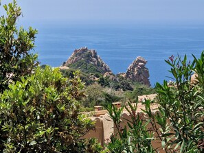 A coastal landscape with rocky formations and greenery.