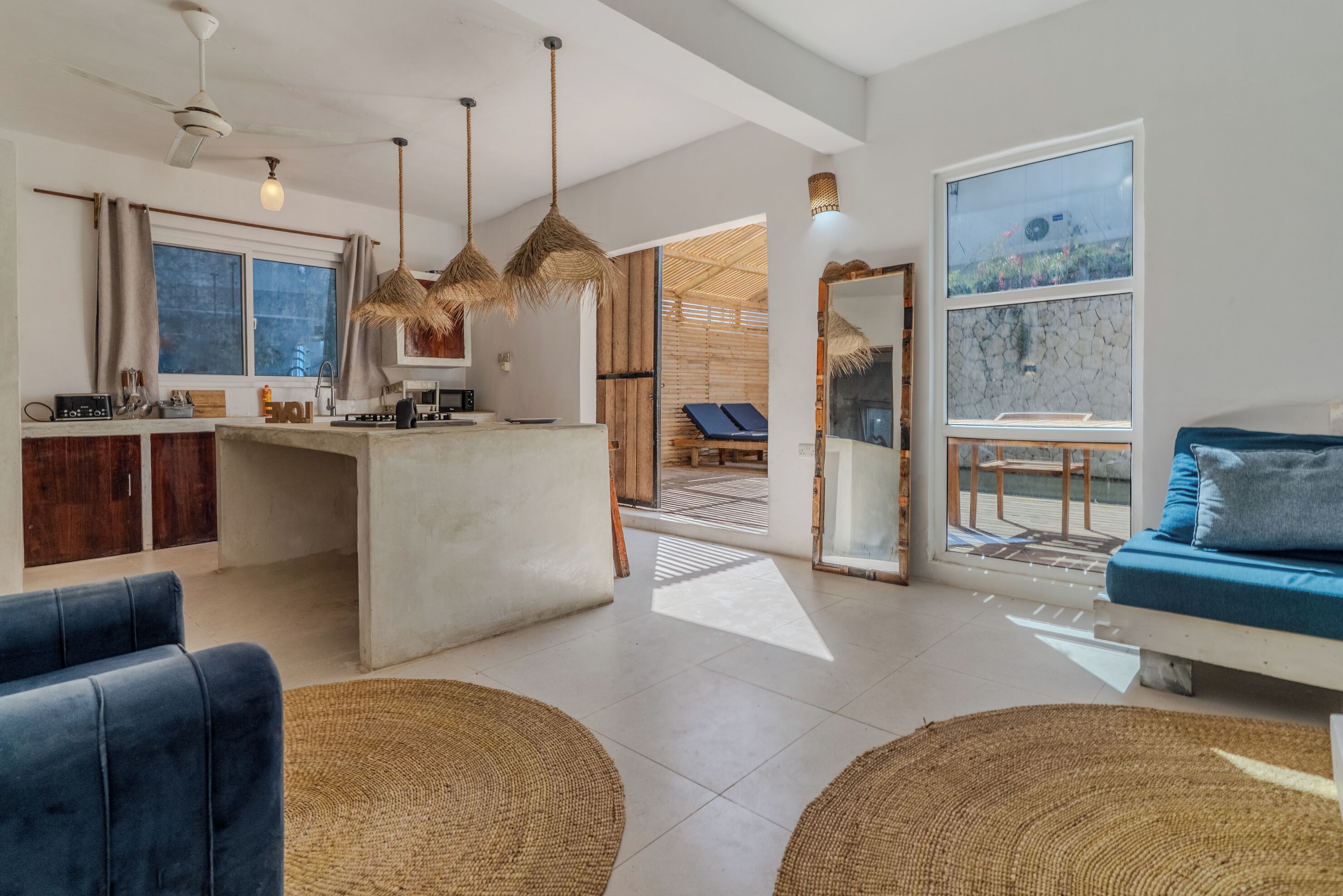 A modern living space with a kitchen, dining area, and a seating area with a view.
