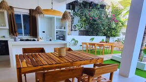 Une cuisine moderne dotée d’un îlot central, d’une table à manger en bois et de chaises.