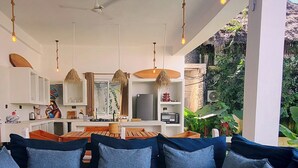 Ein modernes Wohnzimmer mit einem Ecksofa, einem weißen Couchtisch und einer Küche im Hintergrund.