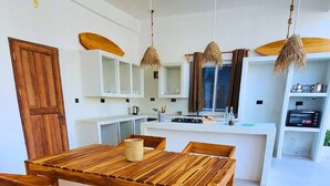 Eine moderne Küche mit Holztisch und Stühlen, weißen Schränken und einem eingebauten Backofen.