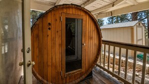 Uma porta em forma de barril de madeira, com puxador de metal, que dá acesso a um espaço interno.