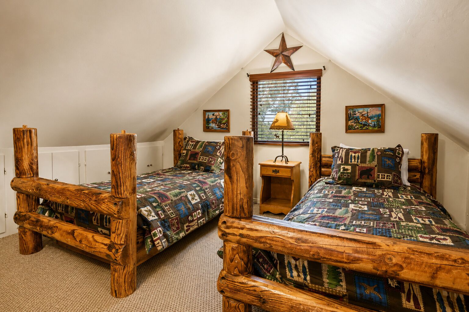 A bedroom with two wooden bunk beds, a star decoration on the ceiling, a window with blinds, and a small bedside table with a lamp.