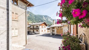 Una vista di una strada con edifici, una montagna sullo sfondo e un cesto di fiori.