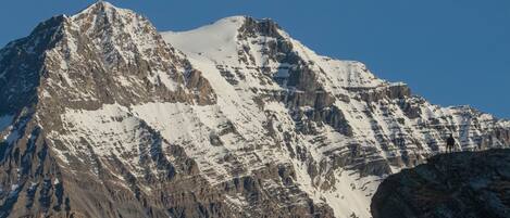 A mountain with snow-covered peaks and rocky terrain.