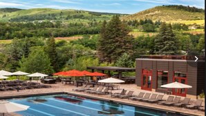 A pool area with lounge chairs and umbrellas, surrounded by greenery and hills. - Fabulous luxury resort hotel suite in delightful Avon w/ AC, WiFi, fitness, pool (Avon)