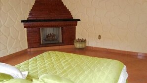 A room with a bed, a fireplace, and a patterned wall.