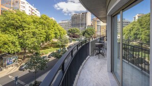 Un balcon offrant une vue sur le paysage urbain, avec des bâtiments et des arbres.