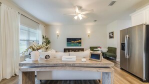 Una cocina moderna con una isla de madera, refrigerador de acero inoxidable y ventilador de techo.