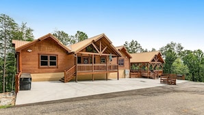 Un chalet en bois doté d’un porche, d’un espace pique-nique couvert et d’une allée pavée.