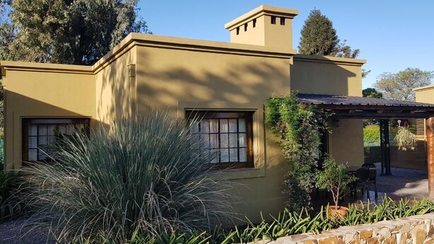 A modern house with a flat roof, large windows, and a covered patio area. - Posada del Santo Green & Rest (Cerrillos)