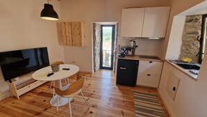 A compact kitchen with a TV, dining table, and chairs. - Casinhas do Amioso T1 in the village of Amioso do Senhor in Alvares - Góis (Góis)