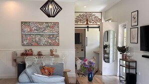 Un salon moderne avec un canapé d’angle, une table basse et un vase décoratif.
