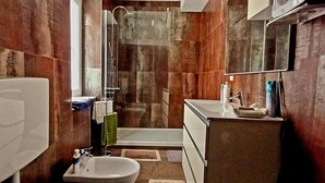 A bathroom with a shower, sink, and mirror. - Al Porto Antico (Genoa)