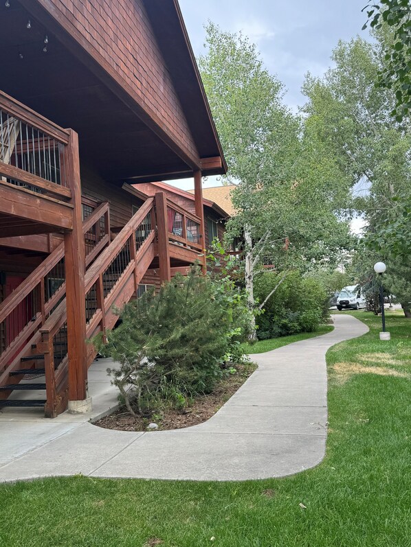A building with a wooden staircase and a covered walkway.