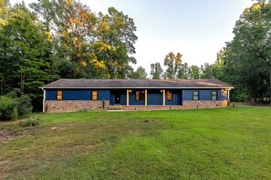 A single-story building with a brick foundation and a dark blue exterior.