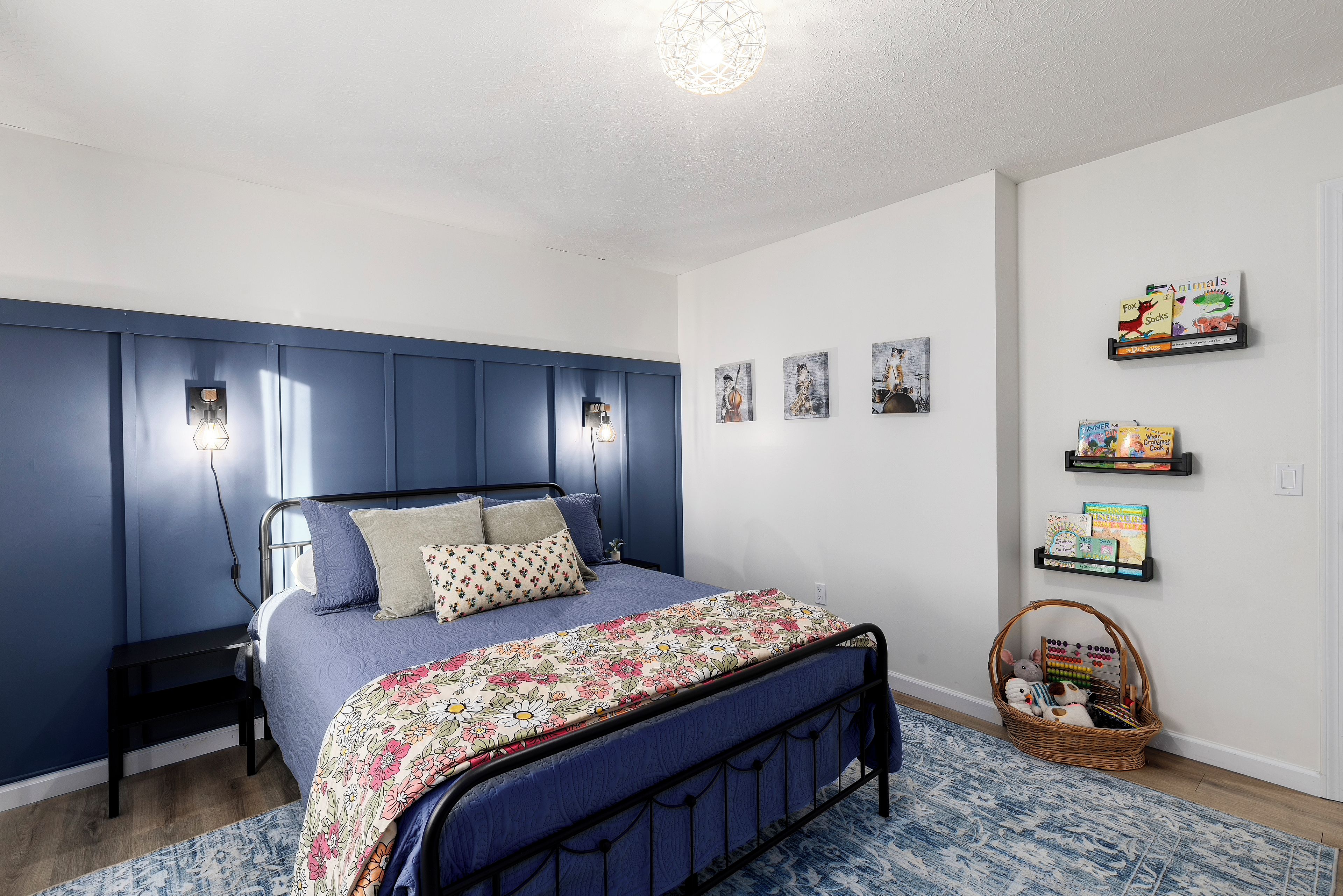 Une chambre à coucher avec un lit, des étagères fixées au mur et un panier.