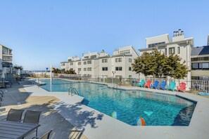 A swimming pool with a deck area, lounge chairs, and a view of a residential building. - Pool Access & Lake Views: Osage Beach Family Gem (Osage Beach)