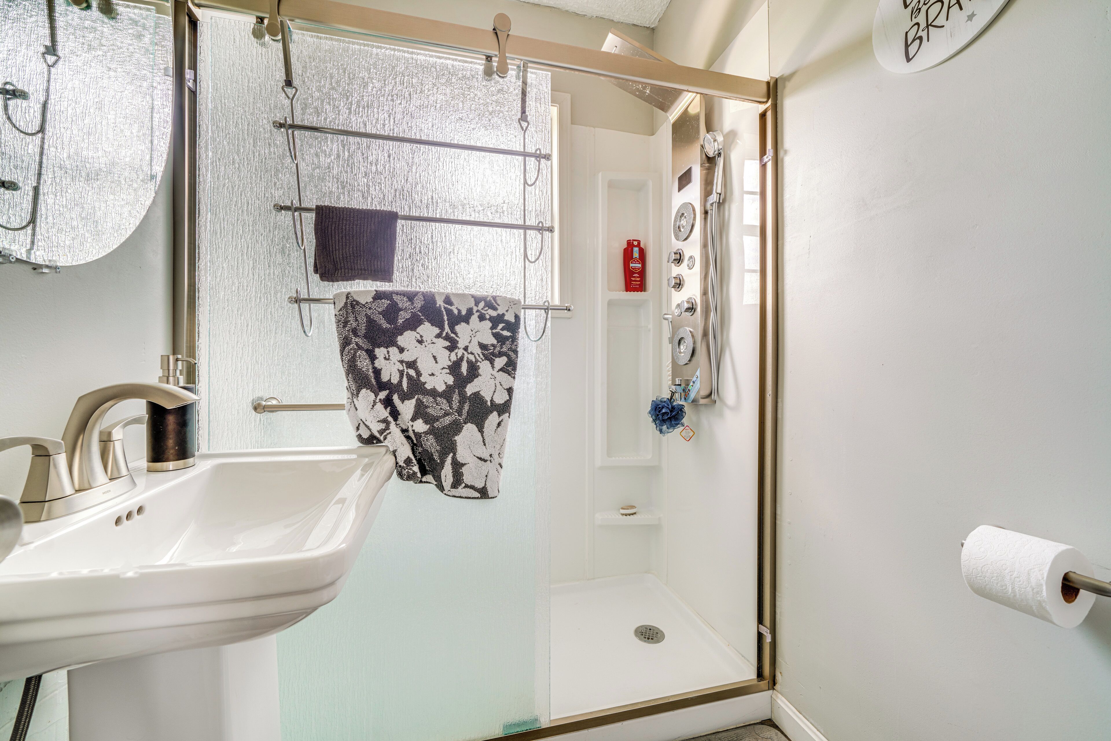 Een badkamer met een wastafel, douche en toilet.