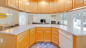 Una cucina con mobili in legno, un piano di lavoro bianco e una lavastoviglie integrata.