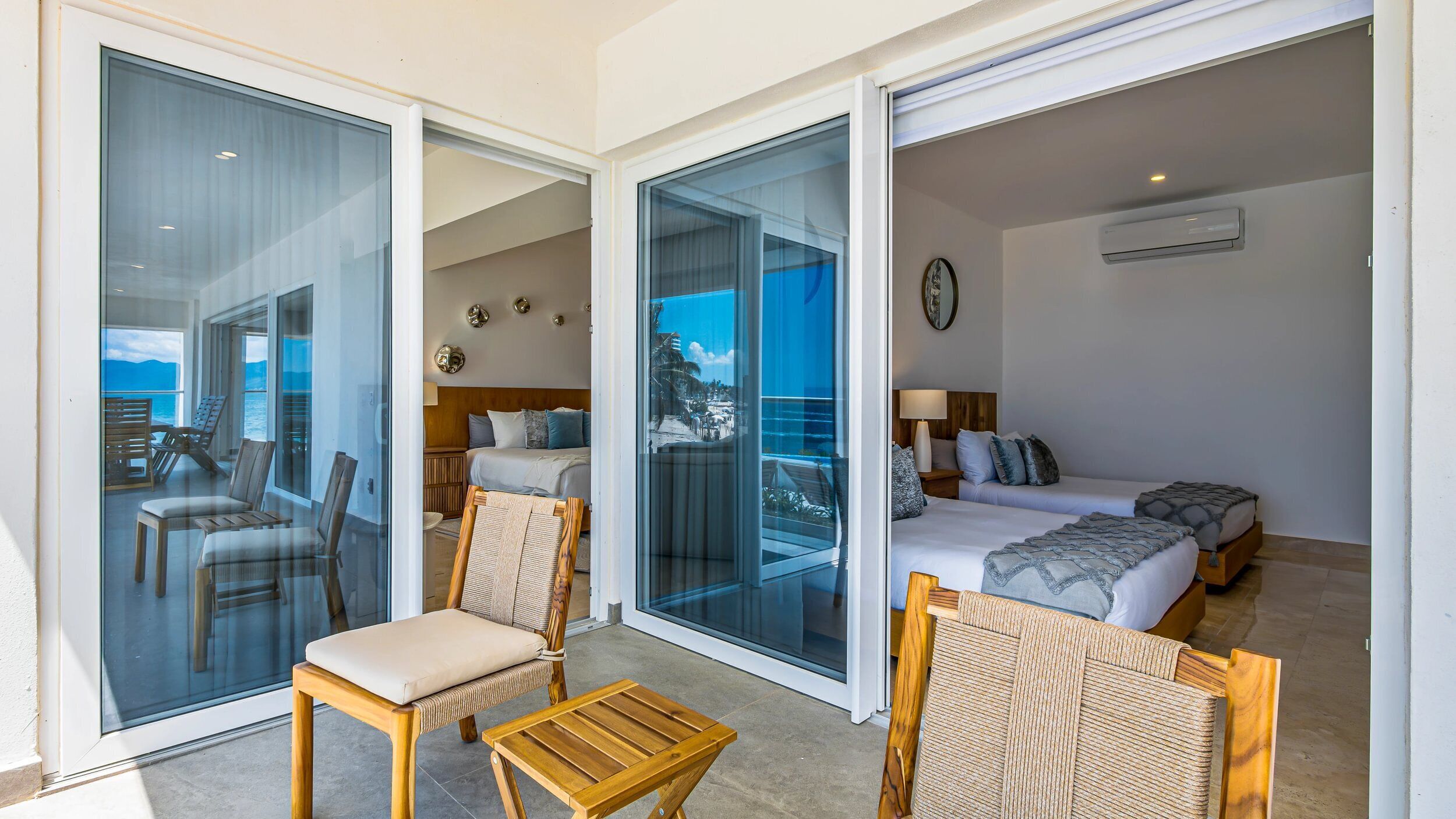 Une chambre d’hôtel avec un balcon, un lit, un canapé et une petite table.