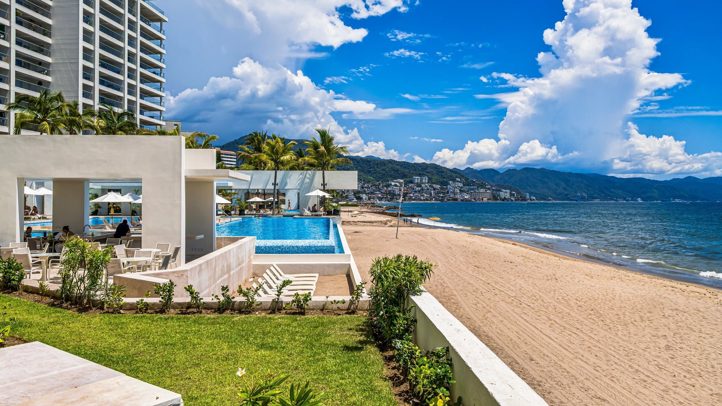 Un hôtel doté d’une piscine, d’une plage et offrant une vue sur l’océan.