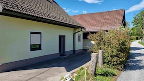 A building with a tiled roof, a small entrance, and a window with blinds. - Lovely apartment in Strau with WiFi (Strau)