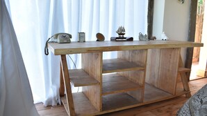 A wooden table with shelves, a rotary phone, a clock, and decorative items. - Sironka Cabin Getaway in Ole Lekurruki, Naromoru. (Mureru Farm)