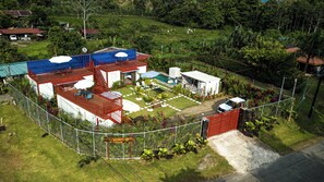 Propiedad cercada con piscina, mobiliario de exterior y un edificio pequeño.