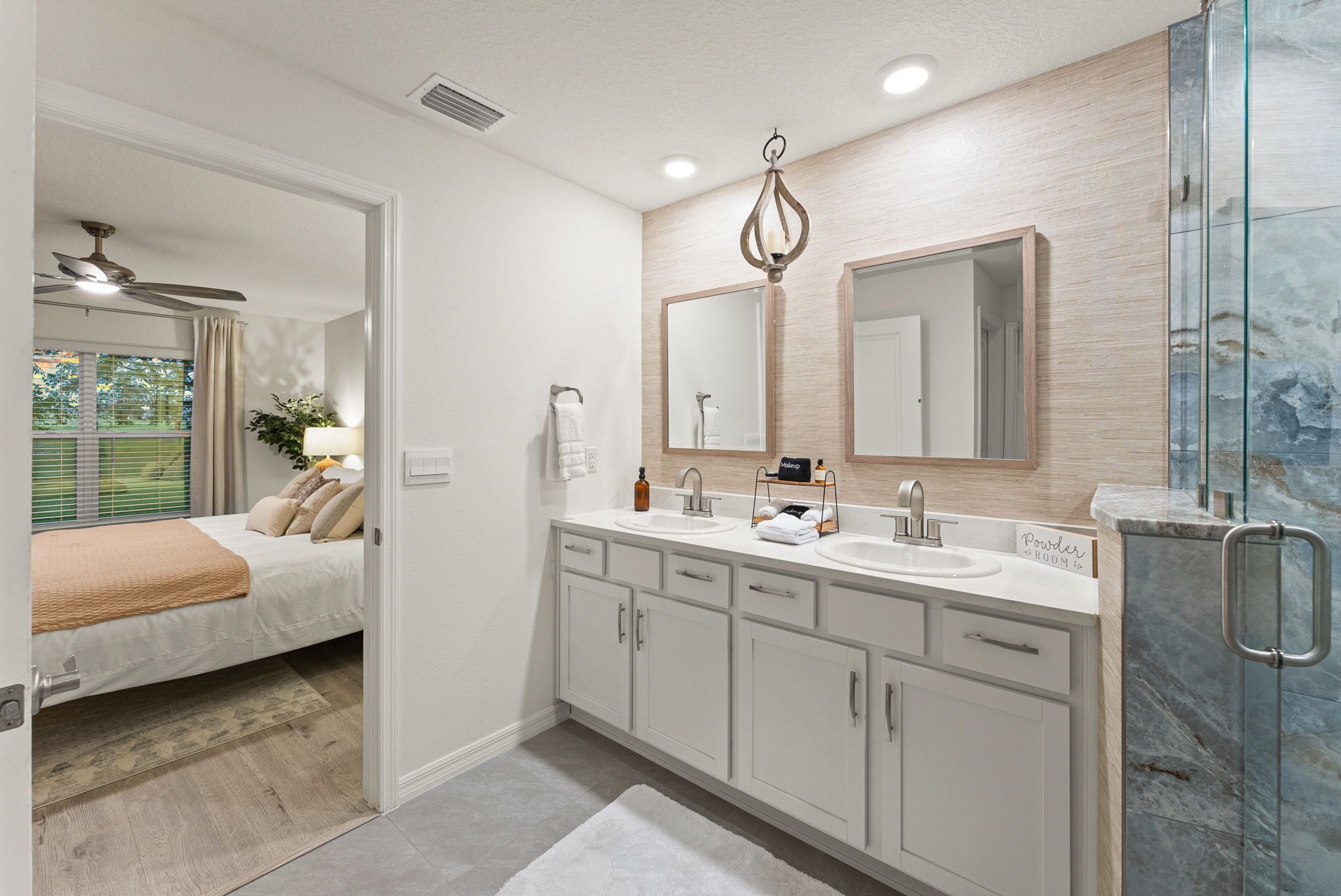 Une salle de bain moderne avec un grand miroir, deux lavabos et une douche.