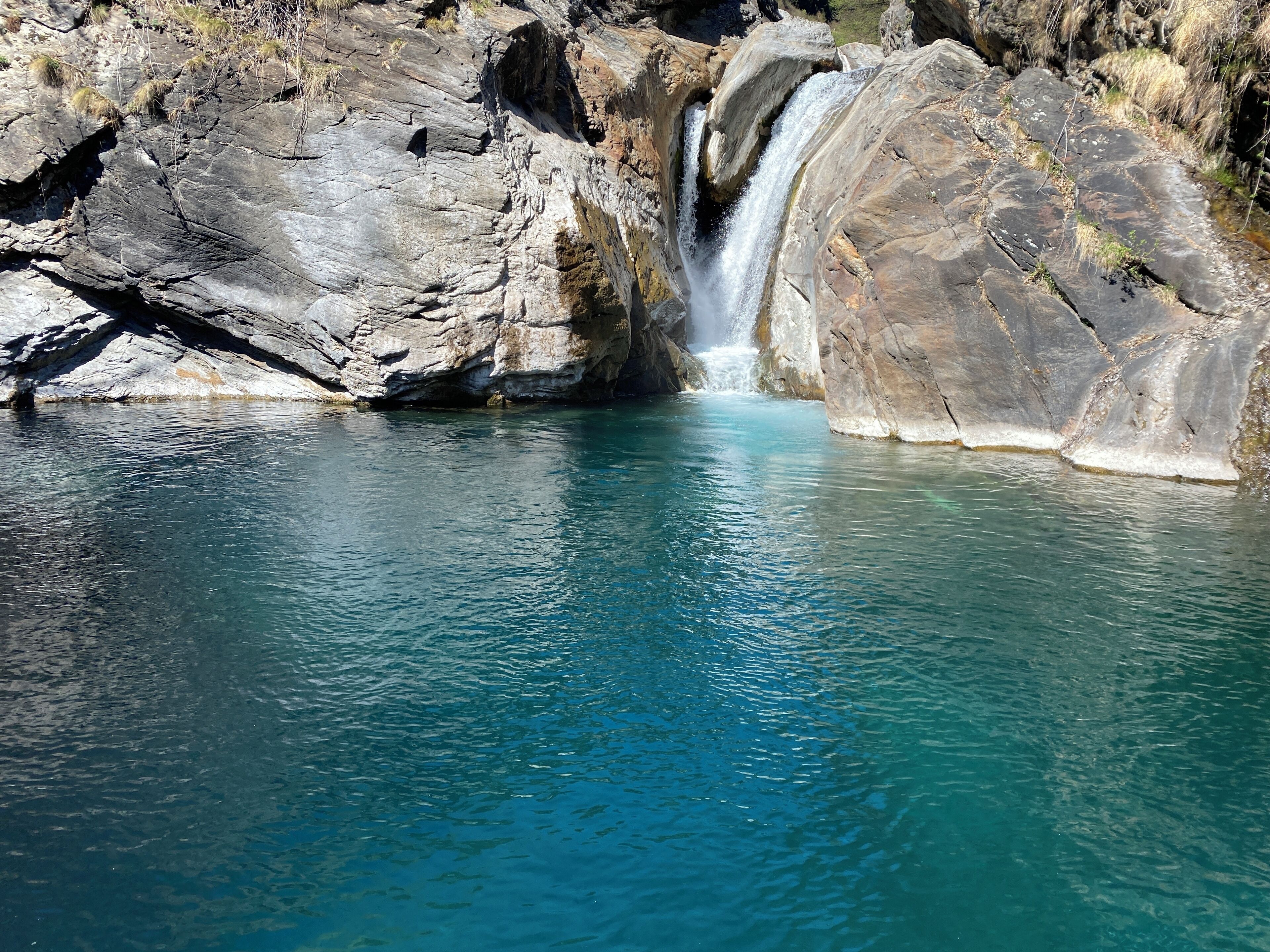 Een natuurlijke waterval in een rotsachtig landschap met helder water.