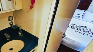 A compact bathroom with a sink, toilet, and a mirror. - Riviera Leisure Yachts Dubai  (Dubai)