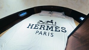 A bed with a white sheet featuring the text "HERMÈS PARIS" and a horse-drawn carriage illustration. - Riviera Leisure Yachts Dubai  (Dubai)