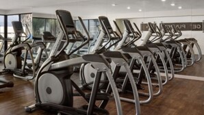 A gym with multiple treadmills arranged in rows, large windows, and a wooden floor. - Chic 2-bedroom apartment with AC, WiFi in wonderful Los Angeles (Los Angeles)