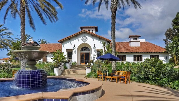 A spa building with a fountain, outdoor seating, and a tiled pool area. - La Costa Comfort - Resort-style Living for 2 (Carlsbad)