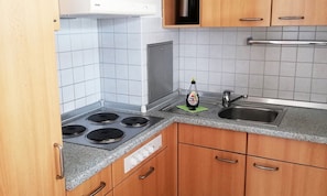 Een koffiezetapparaat/waterkoker, een koelkast, een kookplaat