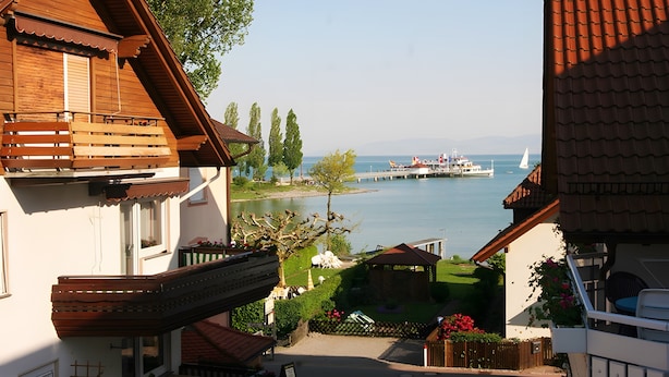 A residential area with a view of a lake, a dock, and a boat. - Sommerhof Rauber – Apartment 'B 04' with Lake View, Shared Garden and Wi-Fi (Immenstaad am Bodensee)