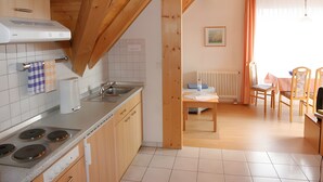 A kitchen with wooden beams, a stove, and a sink. - Sommerhof Rauber - Apartment 'Type B 24' with Lake View, Shared Garden & Wi-Fi (Immenstaad am Bodensee)