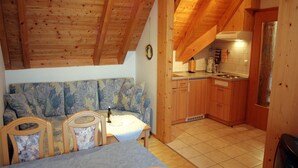 A cozy kitchen with wooden cabinets, a dining area with a table and chairs, and a kitchenette.
