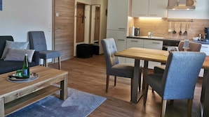 A compact living space with a dining area, kitchenette, and seating.