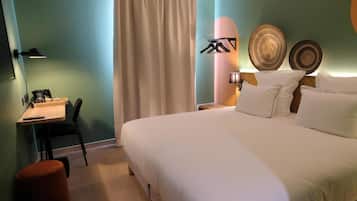 Un dormitorio con cama, escritorio, silla, lámpara y platos decorativos.