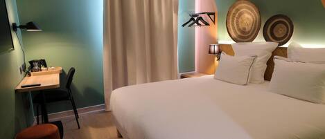 A bedroom with a bed, a desk, a chair, a lamp, and decorative plates.