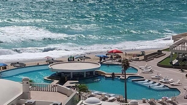 Un espace piscine d’un complexe hôtelier comprenant plusieurs piscines, une plage et une vue sur l’océan.