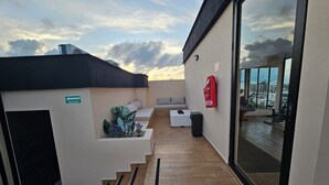 Une terrasse sur le toit avec un espace salon, un extincteur et une vue sur la ville.